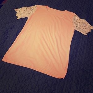 Pink top with crocheted arms.